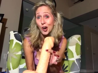 Perky blonde is holding a huge dildo ready to pulverize pussy hole