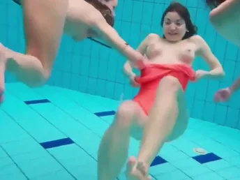 Three jiggish babes swimming in the pool and taking off their bikini